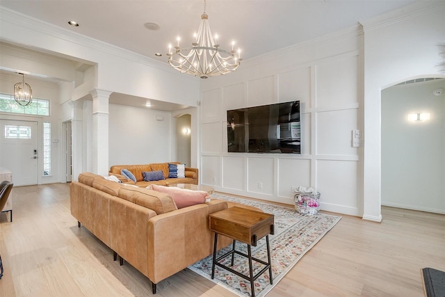 2006 Timber Cove Ct, Weatherford, TX 76087 - living room featuring a chandelier, arched walkways, light wood-style flooring, crown molding, and a decorative wall