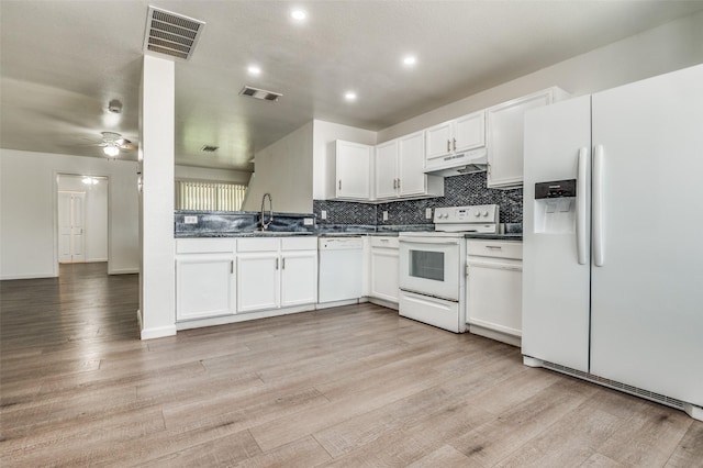 7130 Sorcey Rd, Dallas, TX 75249 - kitchen with white appliances, under cabinet range hood, dark countertops, light wood-type flooring, and tasteful backsplash
