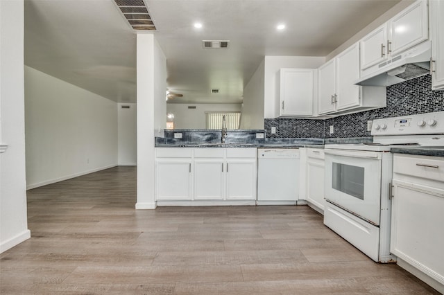 7130 Sorcey Rd, Dallas, TX 75249 - kitchen featuring white appliances, under cabinet range hood, dark countertops, a sink, and white cabinetry