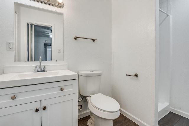 7130 Sorcey Rd, Dallas, TX 75249 - bathroom featuring wood finished floors, toilet, vanity, a shower, and baseboards