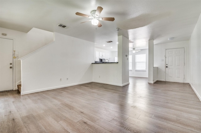 7130 Sorcey Rd, Dallas, TX 75249 - unfurnished living room with a ceiling fan, stairway, light wood-style flooring, and baseboards