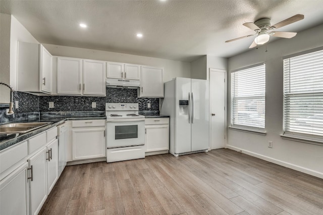 7130 Sorcey Rd, Dallas, TX 75249 - kitchen featuring white appliances, under cabinet range hood, a sink, tasteful backsplash, and dark countertops
