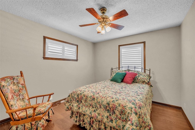 3308 Red Cliff Cir, Temple, TX 76502 - bedroom with baseboards, wood finished floors, ceiling fan, and a textured ceiling