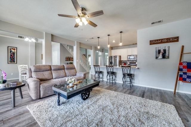 9807 Asheboro St, Frisco, TX 75035 - living area featuring wood finished floors, a ceiling fan, baseboards, and stairway