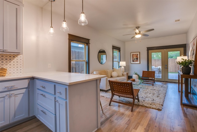 936 N Windomere Ave, Dallas, TX 75208 - kitchen featuring a peninsula, a ceiling fan, tasteful backsplash, wood finished floors, and light countertops