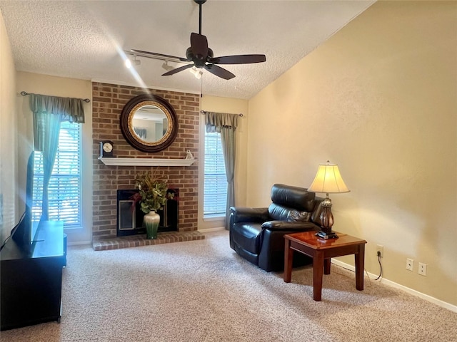 1206 Riverchase Ln Unit 250, Arlington, TX 76011 - living room with a textured ceiling, ceiling fan, carpet floors, baseboards, and a fireplace