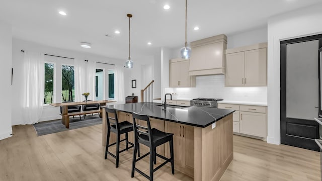 141 Lakeside Dr, Lipan, TX 76462 - kitchen with a sink, high end stove, custom exhaust hood, light wood-style floors, and a breakfast bar area
