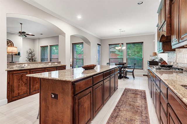 1200 Thornberry Dr, Mckinney, TX 75071 - kitchen with a kitchen island, plenty of natural light, ceiling fan, tasteful backsplash, and ornamental molding
