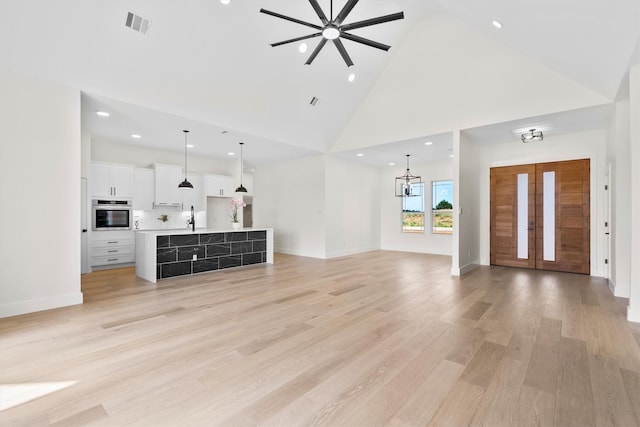 1128 Dixie Estates Way, Whitesboro, TX 76273 - unfurnished living room with high vaulted ceiling, a sink, ceiling fan, recessed lighting, and a chandelier