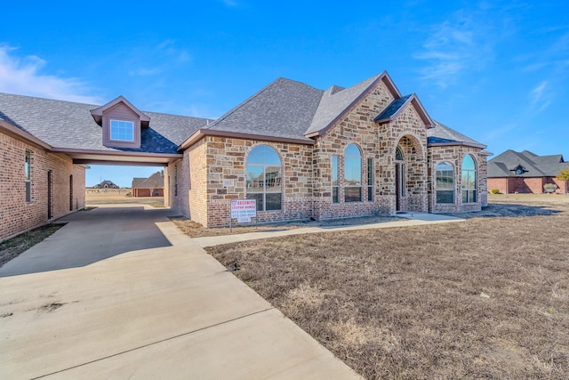 1022 Foolish Pleasure Dr, Terrell, TX 75160 - french country style house with stone siding, brick siding, and roof with shingles
