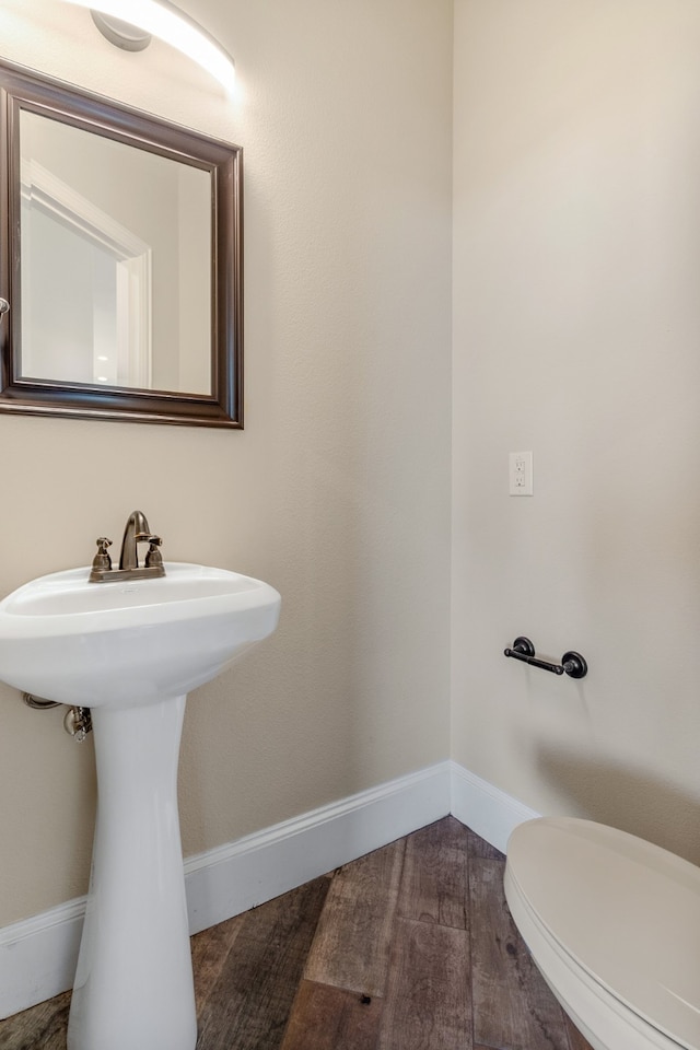 1022 Foolish Pleasure Dr, Terrell, TX 75160 - half bath featuring wood finished floors, toilet, baseboards, and a sink