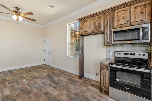 1022 Foolish Pleasure Dr, Terrell, TX 75160 - kitchen with stainless steel appliances, ornamental molding, light wood-type flooring, light stone countertops, and a ceiling fan