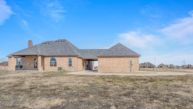 1022 Foolish Pleasure Dr, Terrell, TX 75160 - back of house featuring brick siding, a chimney, a shingled roof, and central air condition unit