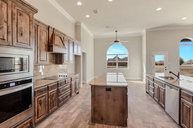 1022 Foolish Pleasure Dr, Terrell, TX 75160 - kitchen with stainless steel appliances, a center island, a ceiling fan, premium range hood, and healthy amount of natural light