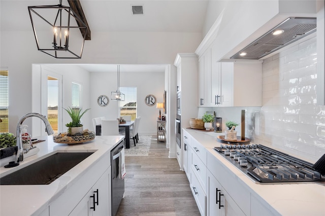 4665 Christie Ave, Caddo Mills, TX 75135 - kitchen featuring stainless steel appliances, wall chimney exhaust hood, a sink, a chandelier, and tasteful backsplash