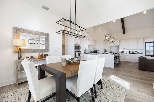 4665 Christie Ave, Caddo Mills, TX 75135 - dining room featuring a chandelier, high vaulted ceiling, light wood finished floors, beamed ceiling, and baseboards