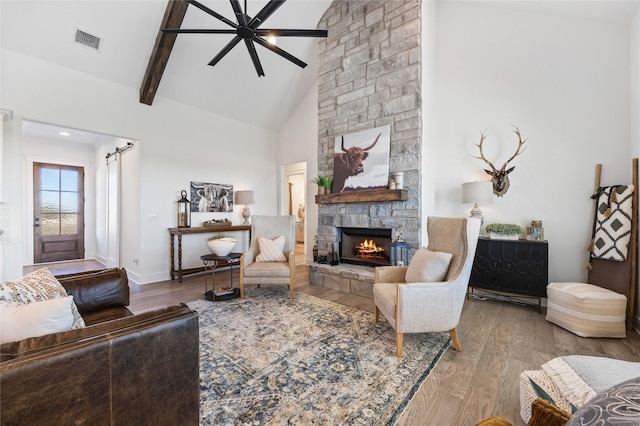 4665 Christie Ave, Caddo Mills, TX 75135 - living area with a stone fireplace, wood finished floors, high vaulted ceiling, beamed ceiling, and a ceiling fan