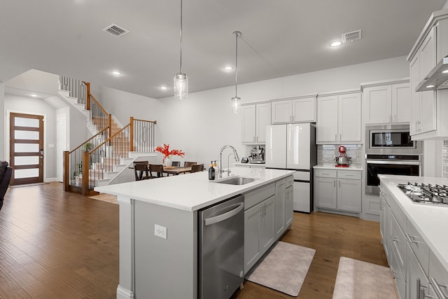 11415 Four Roses Trl, Frisco, TX 75035 - kitchen with stainless steel appliances, a sink, decorative backsplash, light countertops, and dark wood-type flooring