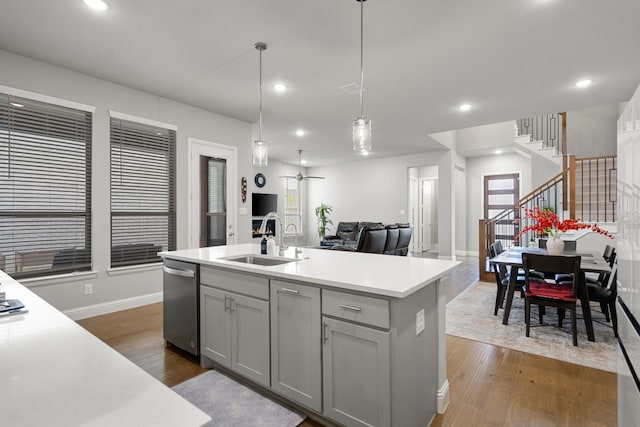 11415 Four Roses Trl, Frisco, TX 75035 - kitchen with stainless steel dishwasher, a sink, open floor plan, light countertops, and dark wood-style flooring