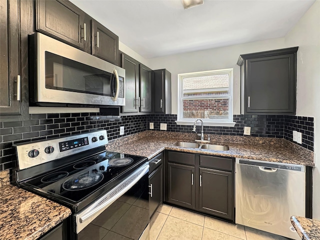 6133 Chalk Hollow Dr, Fort Worth, TX 76179 - kitchen featuring stainless steel appliances, a sink, tasteful backsplash, light tile patterned flooring, and dark stone counters