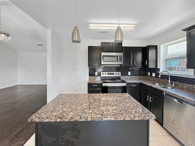 6133 Chalk Hollow Dr, Fort Worth, TX 76179 - kitchen with stainless steel appliances, a sink, decorative backsplash, and hanging light fixtures