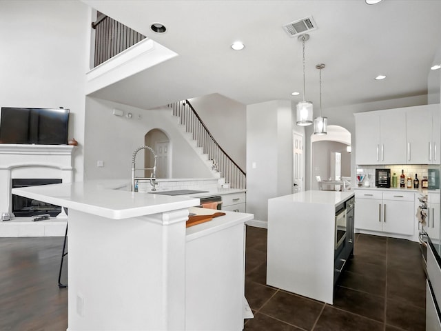 2505 Trailhead Dr, Fort Worth, TX 76177 - kitchen featuring a kitchen island, arched walkways, tasteful backsplash, recessed lighting, and light countertops