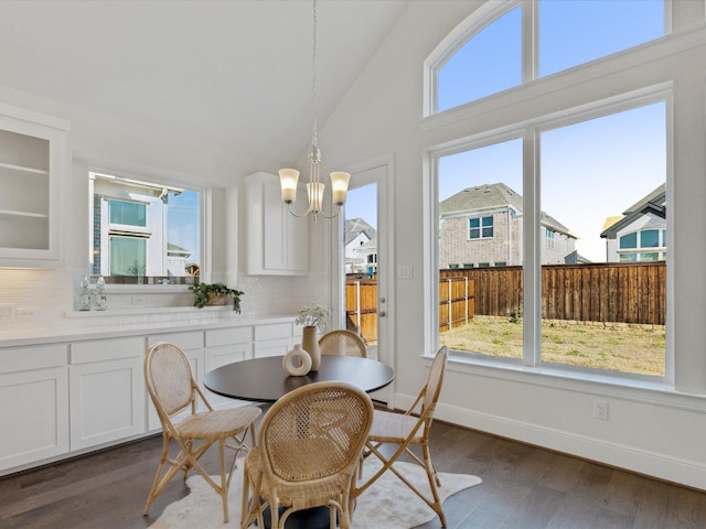 2448 Haft River Rd, Frisco, TX 75034 - dining area with a chandelier, dark wood-style flooring, baseboards, and high vaulted ceiling