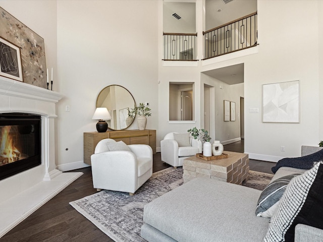 2448 Haft River Rd, Frisco, TX 75034 - living area with a towering ceiling, dark wood-style floors, a fireplace, and baseboards