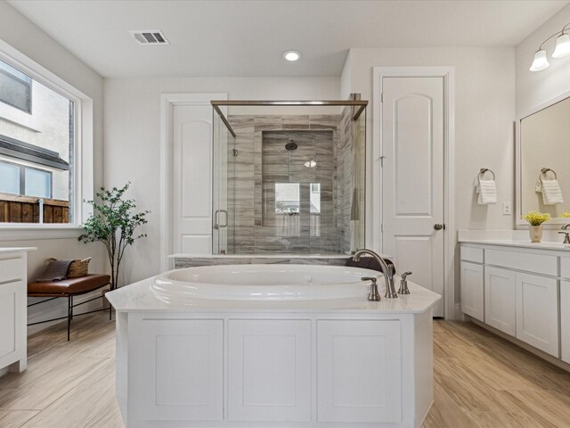 2448 Haft River Rd, Frisco, TX 75034 - bathroom with a garden tub, a stall shower, vanity, recessed lighting, and wood finished floors