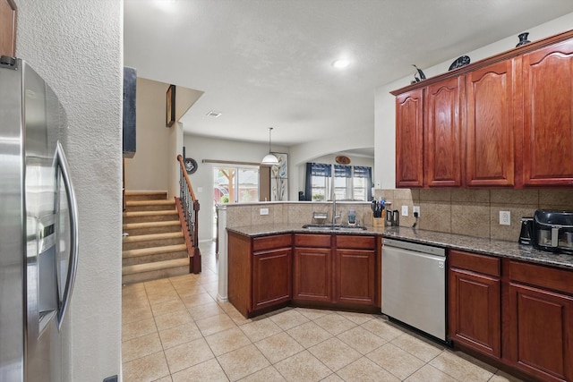 1717 Quail Grove Dr, Fort Worth, TX 76177 - kitchen featuring stainless steel appliances, a sink, tasteful backsplash, light tile patterned floors, and a peninsula