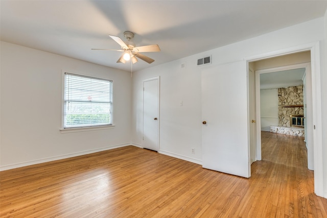 2109 Blake Ave, Dallas, TX 75228 - unfurnished bedroom featuring light wood finished floors, a fireplace, baseboards, and ceiling fan
