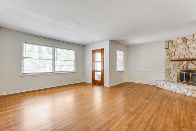 2109 Blake Ave, Dallas, TX 75228 - unfurnished living room with light wood-type flooring, a fireplace, and baseboards
