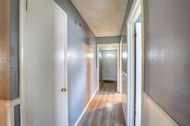 201 Brookhaven Ter, Commerce, TX 75428 - corridor with wood finished floors, a textured ceiling, and baseboards