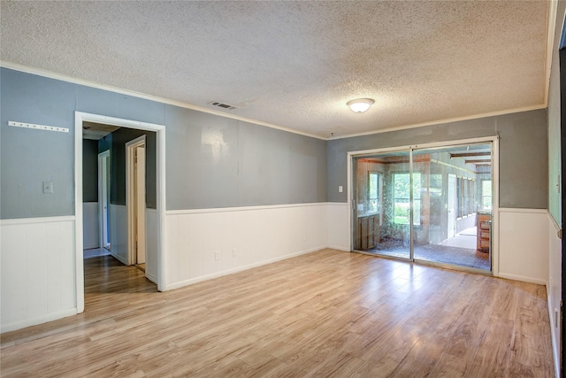 201 Brookhaven Ter, Commerce, TX 75428 - spare room featuring a textured ceiling, crown molding, wood finished floors, and wainscoting