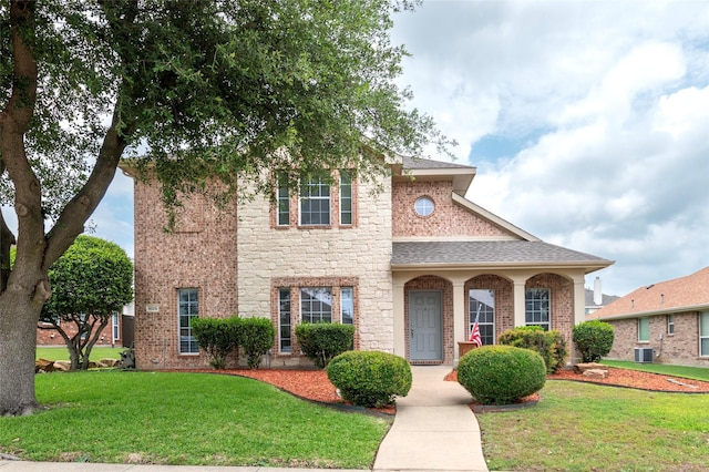 1605 Tanglewood Dr, Allen, TX 75002 - view of front of house featuring a front yard, central AC unit, stone siding, roof with shingles, and brick siding