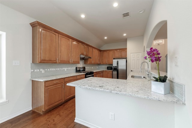 1605 Tanglewood Dr, Allen, TX 75002 - kitchen with stainless steel fridge, gas stove, a sink, a peninsula, and arched walkways