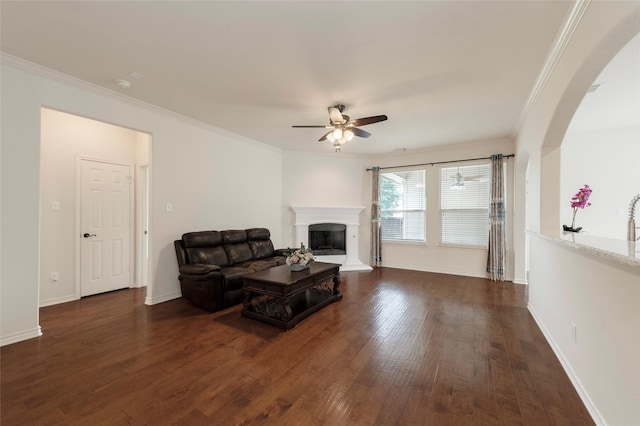 1605 Tanglewood Dr, Allen, TX 75002 - living area with a ceiling fan, dark wood finished floors, arched walkways, crown molding, and a fireplace with raised hearth