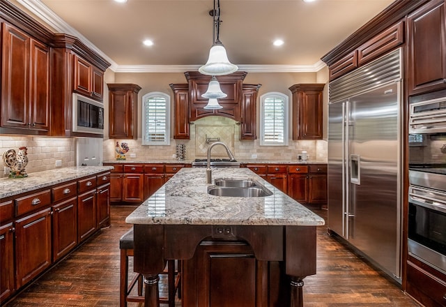 11626 Coronado Trl, Frisco, TX 75033 - kitchen with built in appliances, a sink, dark wood finished floors, ornamental molding, and pendant lighting