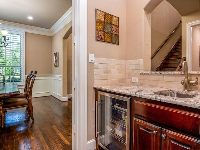 11626 Coronado Trl, Frisco, TX 75033 - indoor bar featuring wine cooler, dark wood-style floors, ornamental molding, tasteful backsplash, and wainscoting