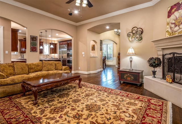 11626 Coronado Trl, Frisco, TX 75033 - living area with arched walkways, dark wood-type flooring, ceiling fan, ornamental molding, and baseboards