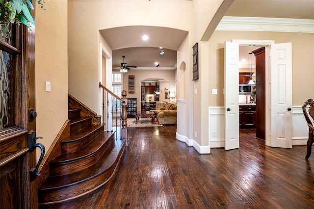 11626 Coronado Trl, Frisco, TX 75033 - foyer with arched walkways, a ceiling fan, ornamental molding, dark wood-type flooring, and baseboards