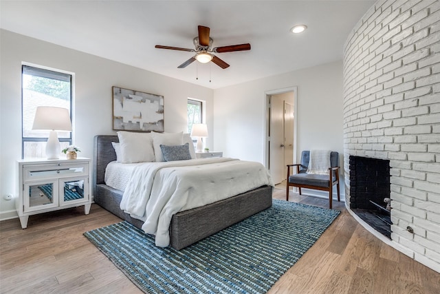 9502 Summerhill Ln, Dallas, TX 75238 - bedroom featuring a brick fireplace, light wood-type flooring, and ceiling fan