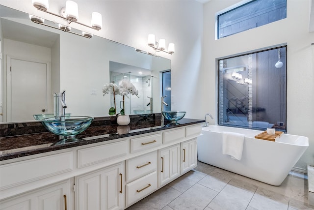 9502 Summerhill Ln, Dallas, TX 75238 - bathroom with a chandelier, double vanity, a freestanding tub, and a stall shower
