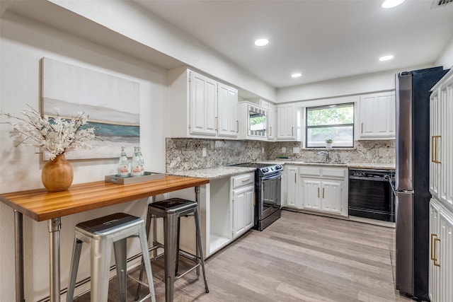 9502 Summerhill Ln, Dallas, TX 75238 - kitchen with appliances with stainless steel finishes, a sink, white cabinetry, light wood finished floors, and tasteful backsplash