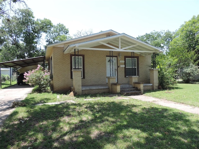 622 N Race, Stephenville, TX 76401 - view of front of house with brick siding, a front lawn, driveway, an attached carport, and a porch