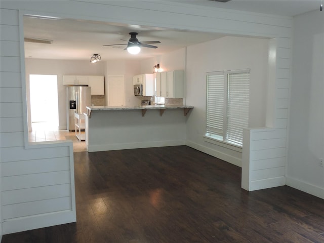 622 N Race, Stephenville, TX 76401 - kitchen with appliances with stainless steel finishes, white cabinets, a peninsula, dark wood-style floors, and light stone counters