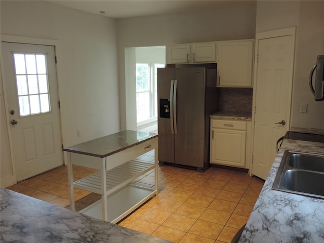 622 N Race, Stephenville, TX 76401 - kitchen with stainless steel refrigerator with ice dispenser, a sink, light tile patterned flooring, and white cabinetry
