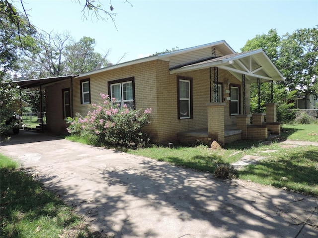 622 N Race, Stephenville, TX 76401 - view of front facade featuring brick siding, covered porch, concrete driveway, and a carport