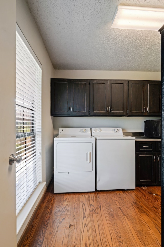 3893 E Fm 906, Powderly, TX 75473 - laundry room featuring cabinet space, washer and clothes dryer, a textured ceiling, and wood finished floors