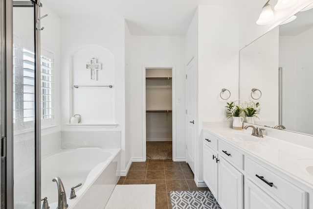 5016 Coney Island Dr, Frisco, TX 75036 - bathroom with a bath, double vanity, tile patterned floors, baseboards, and a spacious closet